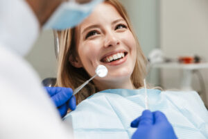 woman sitting in dental chair while professional doctor fixing her teeth