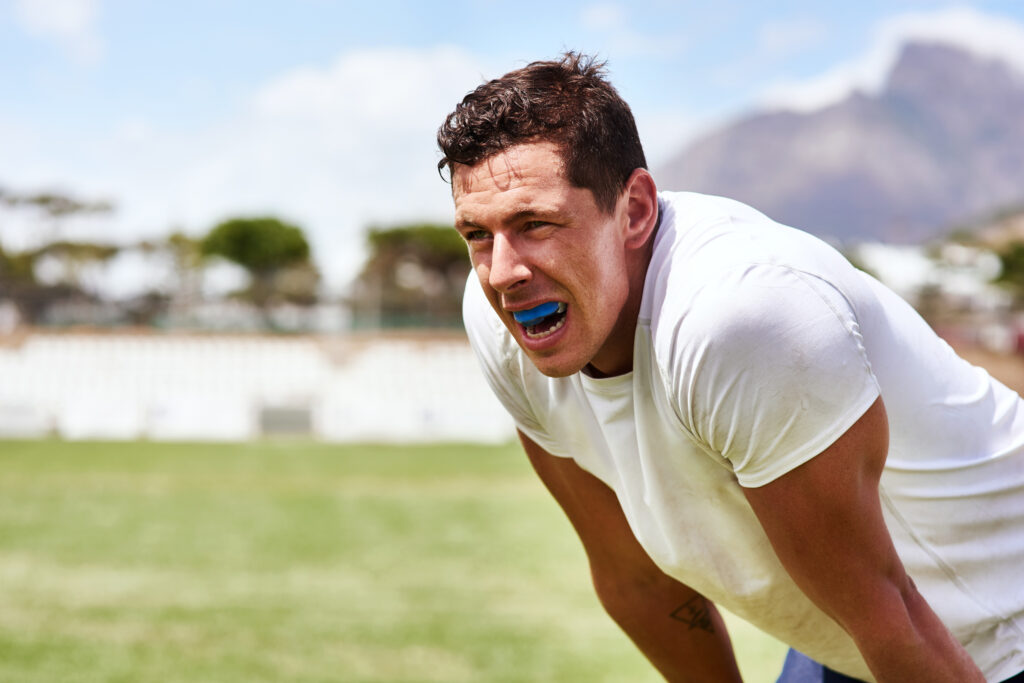 Exhausted athlete recovering on field