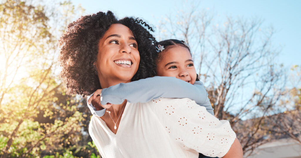 Mother, child and family outdoor with love and care for piggyback to a play game for fun in backyard. Smile of woman and girl kid in nature to relax together in summer with a hug for support or trust.